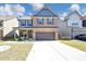 Charming two-story brick home with a welcoming front porch and a well-manicured lawn at 2375 Walker Dr, Hampton, GA 30228
