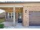 Inviting front porch with brick accents, classic columns, and a stylish entry door at 2375 Walker Dr, Hampton, GA 30228