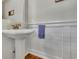 Chic half-bathroom featuring a pedestal sink, wainscoting, and modern fixtures at 326 Carmichael Cir, Canton, GA 30115