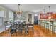 Open dining area featuring hardwood floors, a stylish chandelier, and wainscoting with brick accents at 326 Carmichael Cir, Canton, GA 30115