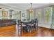 Sunlit dining area with hardwood floors, a decorative chandelier, and seamless access to the living room at 326 Carmichael Cir, Canton, GA 30115