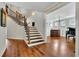 Bright foyer with hardwood floors, elegant staircase, and view of the living room with piano at 326 Carmichael Cir, Canton, GA 30115