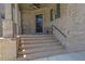 Charming brick front porch with elegant columns and seating area creates a welcoming entrance at 326 Carmichael Cir, Canton, GA 30115