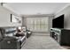 Sitting area with a large flat screen TV, two black recliners and three windows at 326 Carmichael Cir, Canton, GA 30115