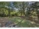 Expansive, fenced backyard with lush green grass, mature trees, and an outdoor table setting at 510 Birch Ridge Ct, Roswell, GA 30076