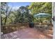 Relaxing outdoor deck with table, umbrella, and grill nestled among mature trees and natural surroundings at 510 Birch Ridge Ct, Roswell, GA 30076