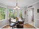 Sun-filled dining area with a large window, hardwood flooring, and a decorative light fixture at 510 Birch Ridge Ct, Roswell, GA 30076