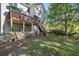 Backyard view highlighting the wooden deck, stairs, fenced yard, and mature trees creating a peaceful setting at 510 Birch Ridge Ct, Roswell, GA 30076