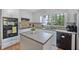 Modern kitchen featuring updated appliances, white cabinets, an island, and hardwood floors at 510 Birch Ridge Ct, Roswell, GA 30076