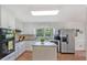 Well-lit kitchen offering white cabinetry, stainless steel refrigerator, and modern appliances at 510 Birch Ridge Ct, Roswell, GA 30076
