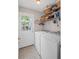 Well-lit laundry room featuring a side-by-side washer and dryer and built-in shelving at 510 Birch Ridge Ct, Roswell, GA 30076