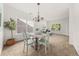Bright dining room features a stylish chandelier, large windows, and elegant wall paneling at 5209 Carrington Park Dr, Powder Springs, GA 30127