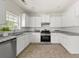 Well-lit kitchen with white cabinets, stainless steel appliances, granite counters, and a tiled backsplash at 5209 Carrington Park Dr, Powder Springs, GA 30127