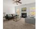 Bright living room with neutral carpet, a ceiling fan, and a fireplace, creating a cozy atmosphere at 5209 Carrington Park Dr, Powder Springs, GA 30127