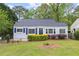 Charming home featuring a well-manicured lawn and tasteful landscaping with blue shutters on a sunny day at 561 Allendale Dr, Decatur, GA 30032