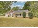 Charming one-story home with manicured lawn, front porch, bay window and black shuttered windows at 70 Summer Walk Dr, Covington, GA 30016