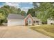 One-story home with two car garage, bay window, covered porch and black shuttered windows at 70 Summer Walk Dr, Covington, GA 30016