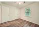 Bedroom with wood-look flooring, ceiling fan, window, and closet storage at 1718 Country Park Way, Lawrenceville, GA 30043