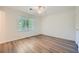 Cozy bedroom with wood-look flooring, a ceiling fan, and a window bringing in natural light at 1718 Country Park Way, Lawrenceville, GA 30043