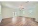 Bright living room with wood-look flooring, ceiling fan, and access to a porch or patio through glass panel doors at 1718 Country Park Way, Lawrenceville, GA 30043