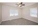 Bedroom featuring neutral carpet, ceiling fan, and two large windows with blinds at 2179 Jernigan Drive Se Dr, Atlanta, GA 30315