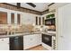Classic kitchen with white cabinets, tile backsplash, modern appliances, and tile flooring at 23101 Plantation Ne Dr, Atlanta, GA 30324