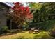 Backyard featuring lush greenery, mature trees, and seating for outdoor entertaining at 4727 Emily Sw Dr, Lilburn, GA 30047