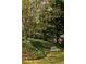 An enchanting garden with flowering trees and a white bench offers a peaceful retreat at 4727 Emily Sw Dr, Lilburn, GA 30047