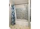 Cozy bathroom featuring a tub with tiled wall and blue floral shower curtain at 4727 Emily Sw Dr, Lilburn, GA 30047