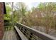 Outdoor deck featuring wooden bench with elevated view of lush trees at 4727 Emily Sw Dr, Lilburn, GA 30047