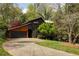 Charming home with wood siding, a black garage door, and a well-manicured lawn and driveway at 4727 Emily Sw Dr, Lilburn, GA 30047