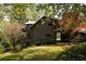 Unique exterior featuring dark wood, two balconies, and a lush green yard with mature trees at 4727 Emily Sw Dr, Lilburn, GA 30047