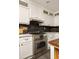 The kitchen features white cabinets, a stainless steel oven and range, and black backsplash at 4727 Emily Sw Dr, Lilburn, GA 30047