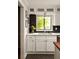 The kitchen features a large window, white cabinets, and a sleek black backsplash at 4727 Emily Sw Dr, Lilburn, GA 30047