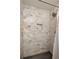 Bathroom with a shower featuring tiled walls, recessed storage, and updated fixtures at 4727 Emily Sw Dr, Lilburn, GA 30047