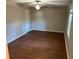 Bright bedroom with wood-look flooring, ceiling fan, and natural light from the windows at 6334 Forester Way, Lithonia, GA 30038