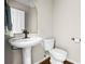 Cozy powder room with pedestal sink, and a round gold trimmed mirror at 844 Nob Ridge Dr, Marietta, GA 30064