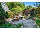 Cozy backyard fire pit area with gravel, Adirondack chairs, lush plants, and privacy fence perfect for entertaining at 844 Nob Ridge Dr, Marietta, GA 30064