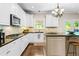 Open kitchen features white cabinets, a center island, stainless appliances, and stone countertops at 844 Nob Ridge Dr, Marietta, GA 30064