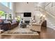 Beautiful living room with a fireplace, large windows, and hardwood flooring with staircase in background at 844 Nob Ridge Dr, Marietta, GA 30064