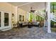 Covered outdoor patio with comfortable seating, ceiling fan, and access to stairs leading to the backyard at 844 Nob Ridge Dr, Marietta, GA 30064