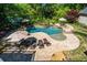 Stunning aerial view of a freeform pool, lush landscaping, and stone patio with lounge chairs and umbrellas at 844 Nob Ridge Dr, Marietta, GA 30064