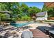Lounge by the pool with stone waterfall feature, surrounded by lush greenery and seating areas at 844 Nob Ridge Dr, Marietta, GA 30064