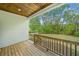A cozy back porch with a wooden ceiling and railing overlooks the lush backyard at 1809 Cassville Nw Rd, Cartersville, GA 30121