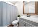 Bathroom features a gray vanity with a framed mirror and a shower with a blue curtain at 1809 Cassville Nw Rd, Cartersville, GA 30121