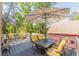 Outdoor deck with table and chairs under a large umbrella, nestled among trees, creating a private space to relax and entertain at 2733 Winburn Ter, East Point, GA 30344
