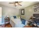 Well-lit bedroom features hardwood floors, comfortable bed, and desk with chair, and a ceiling fan at 2733 Winburn Ter, East Point, GA 30344