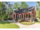 Quaint red home featuring a screened-in porch, landscaped yard, and inviting curb appeal at 2733 Winburn Ter, East Point, GA 30344