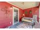 Bright sunroom showcases red walls, a swing, and decorative accents, creating a warm, inviting space to unwind and relax at 2733 Winburn Ter, East Point, GA 30344