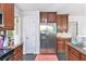 Well-lit kitchen featuring stainless steel appliances, wood cabinets, and durable tile floors at 2958 Paul Harris Rd, Dallas, GA 30157